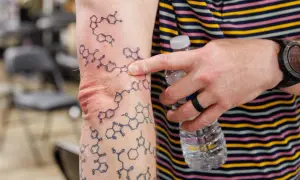 Tatuaż wzór chemiczny na ramieniu, przedstawiający złożone struktury molekularne.