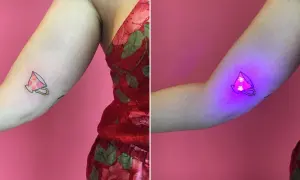 Uroczy tatuaż filiżanki z kwiatami, który pod wpływem światła UV staje się magicznym, fluorescencyjnym dziełem sztuki.