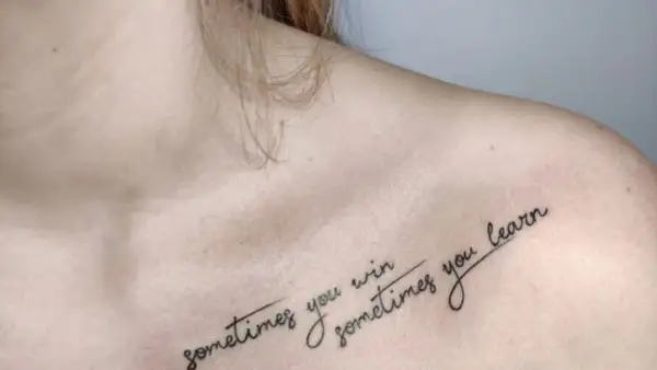 Delikatny tatuaż na dekolcie z napisem "sometimes you win, sometimes you learn".